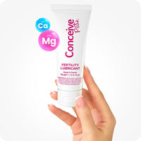 Max Fertility Lubricant Bundle featuring image of 75ml Conceive Plus tube held in hand, highlighting calcium and magnesium ions. White tube has pink branding.