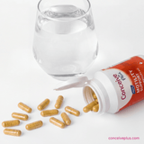 Conceive Plus motility support capsules with a glass of water on a white background