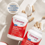 Two bottles of Conceive Plus Men's Motility Support dietary supplement capsules arranged on a light beige surface with scattered capsules and a glass in the background. A white circular badge reads 'Improve sperm motility and vitality.